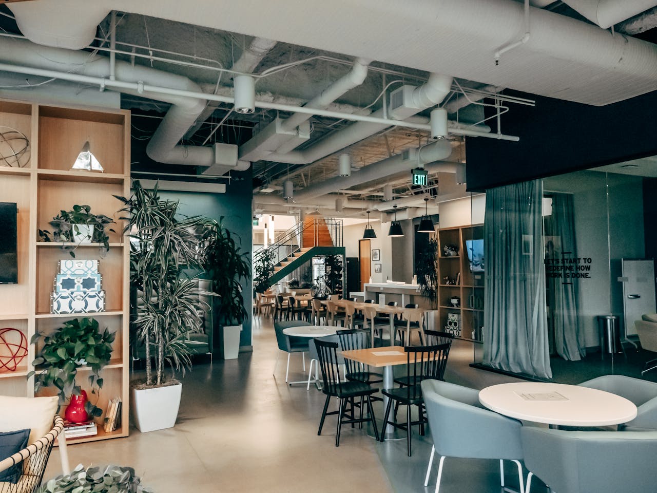 Spacious contemporary office lounge featuring stylish furniture and indoor greenery.
